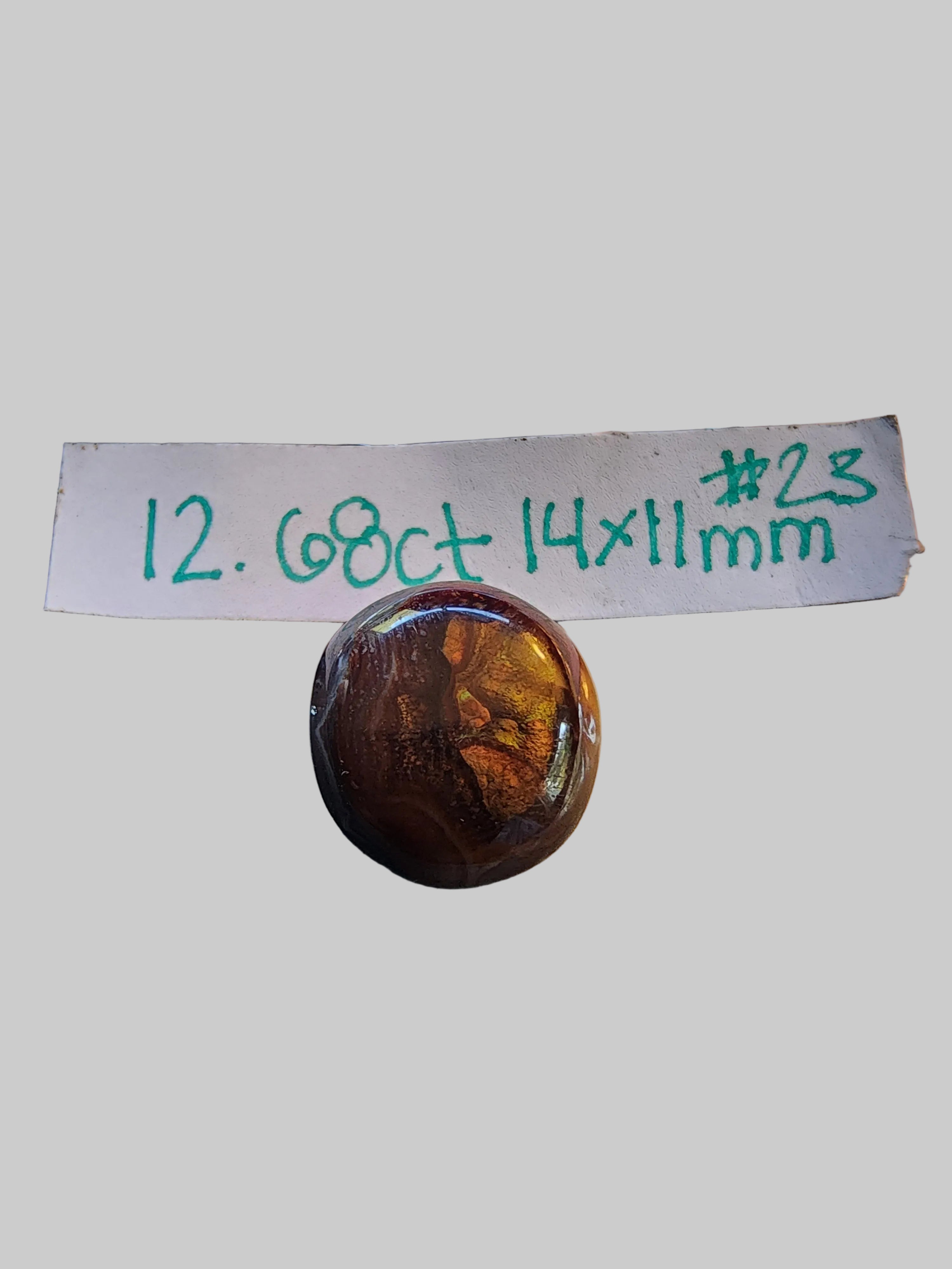 A polished round brown gemstone or cabochon The label reads '12.68ct 14x11mm
